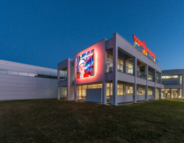 Modern building with illuminated sign at dusk.