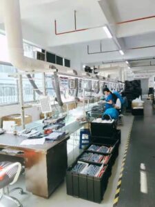 Workers assembling electronics in a factory.